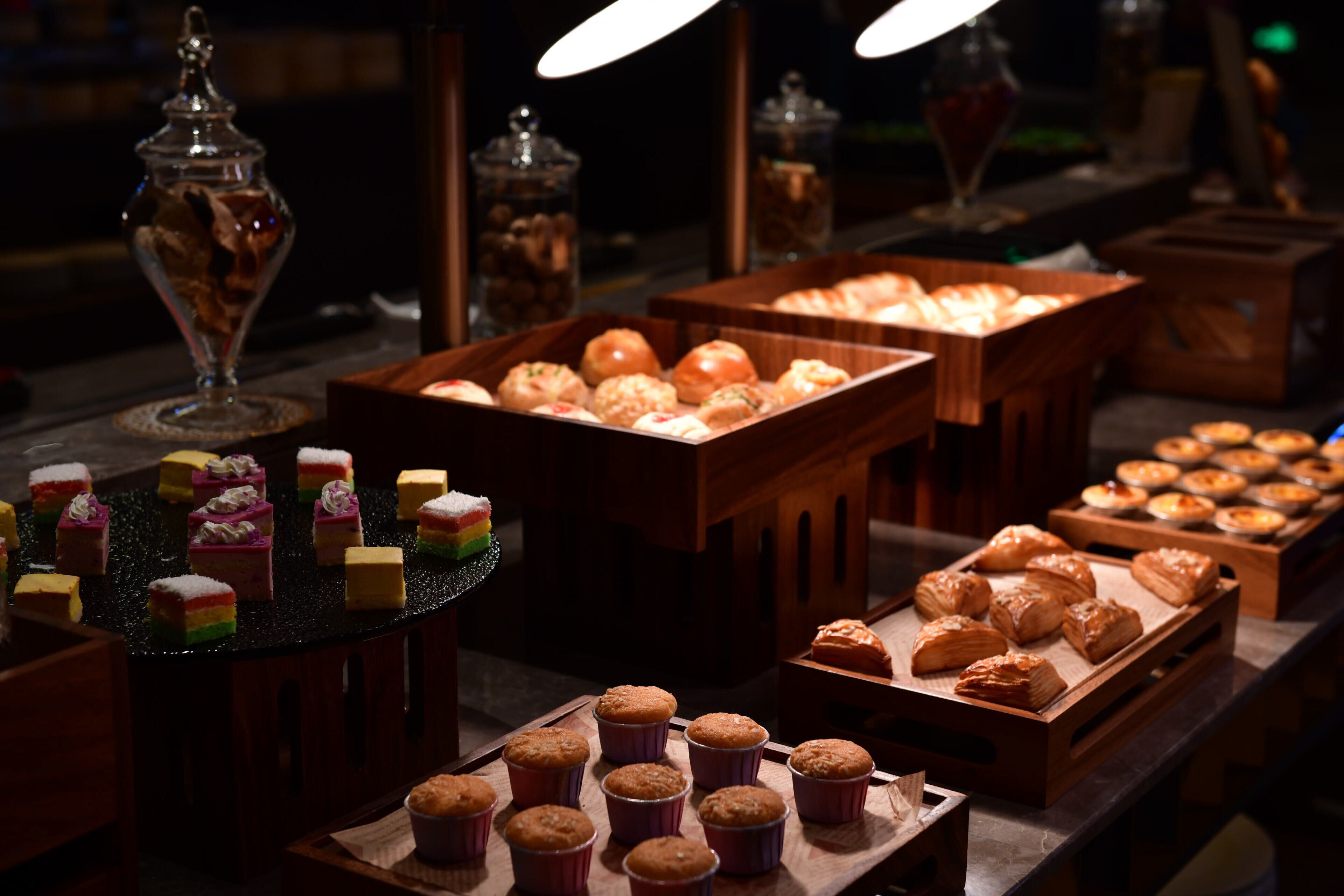 A buffet with various baked goods and desserts.