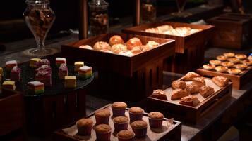 A buffet with various baked goods and desserts.
