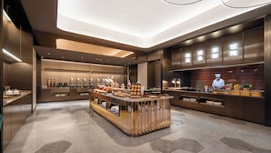 Een moderne keuken met een centraal eiland, inbouwapparatuur en een kok in actie.