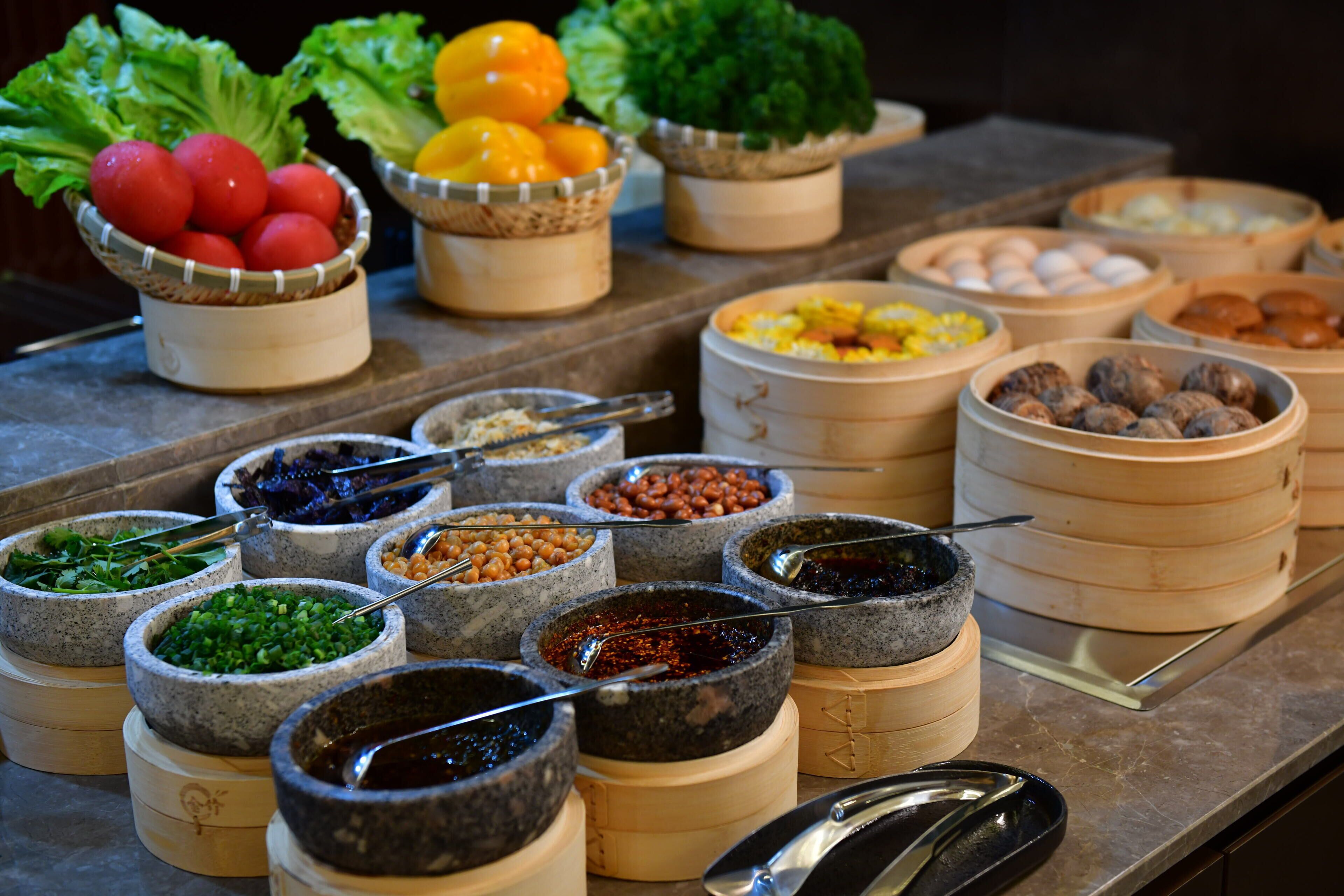 A buffet with various food items in bowls and baskets.