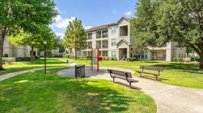 A residential building with a central courtyard, outdoor exercise equipment, and benches. - Landing | Spectacular 2BD in Copperfield (Cypress)