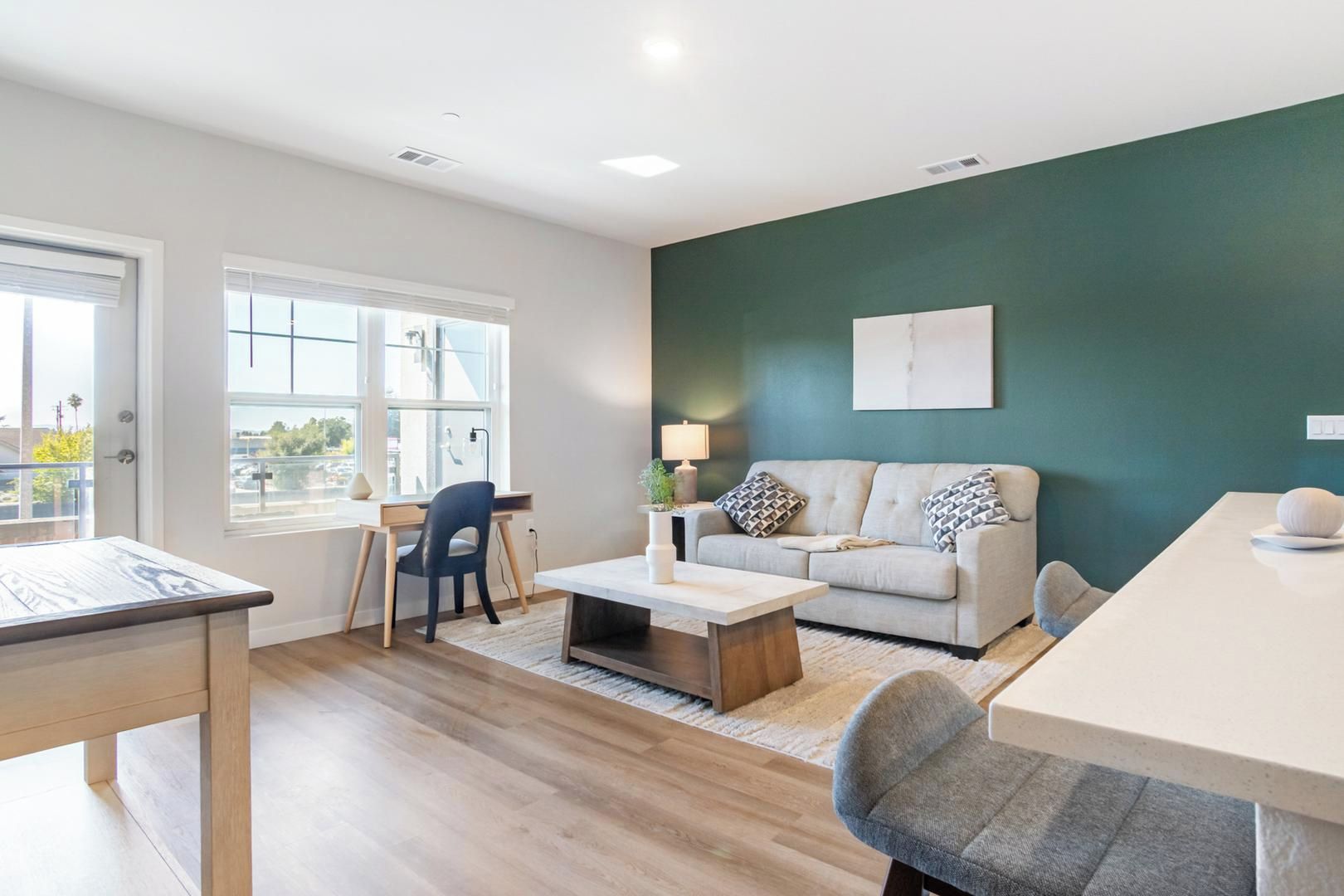 Een moderne woonkamer met een bank, salontafel en een eethoek met een tafel en stoelen.