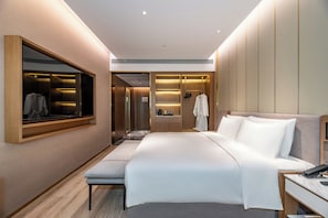 A modern hotel room with a large bed, a bedside table, a built-in wardrobe, and a mirror. - Orange Crystal Hongyadong Hotel (Chongqing)