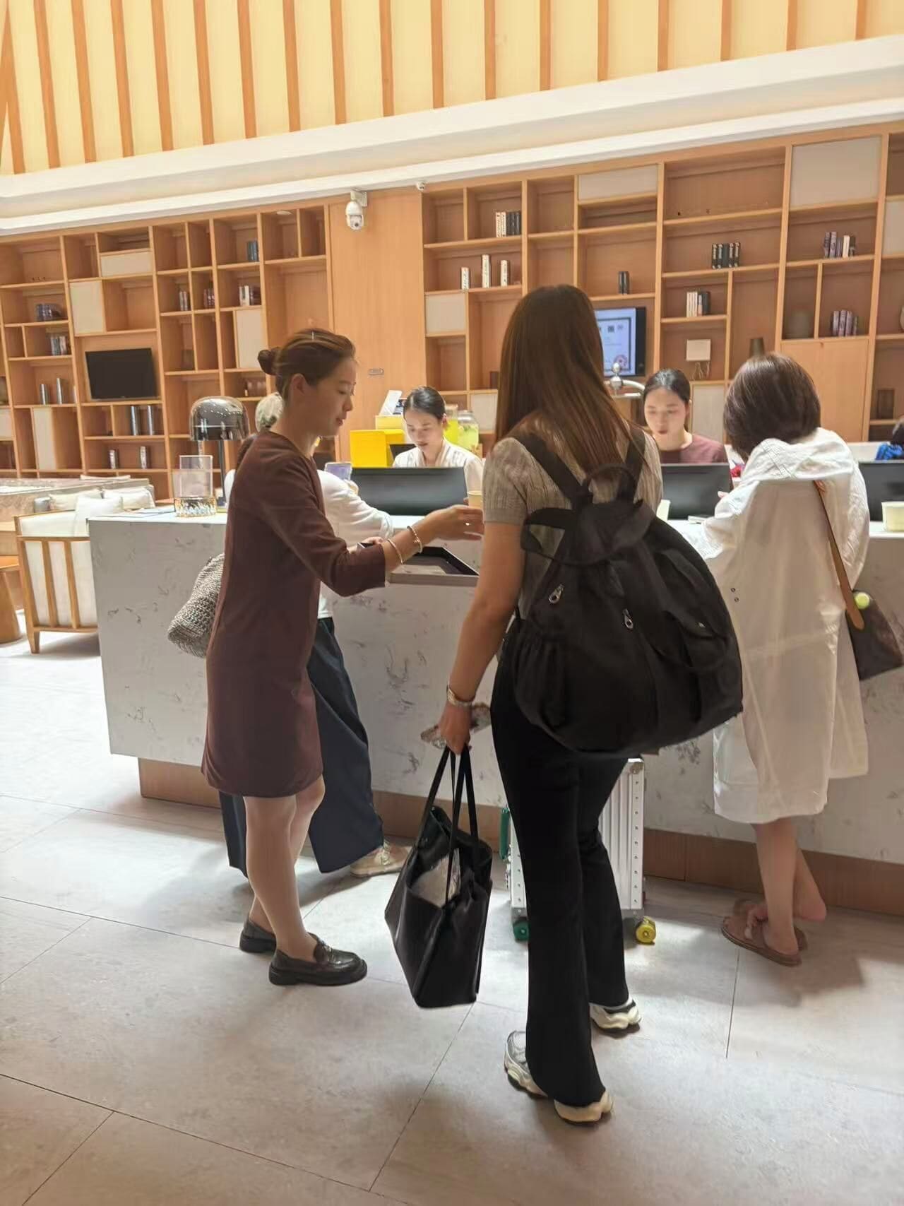Un área de recepción con mostrador, varias estanterías con libros y una cámara de seguridad.