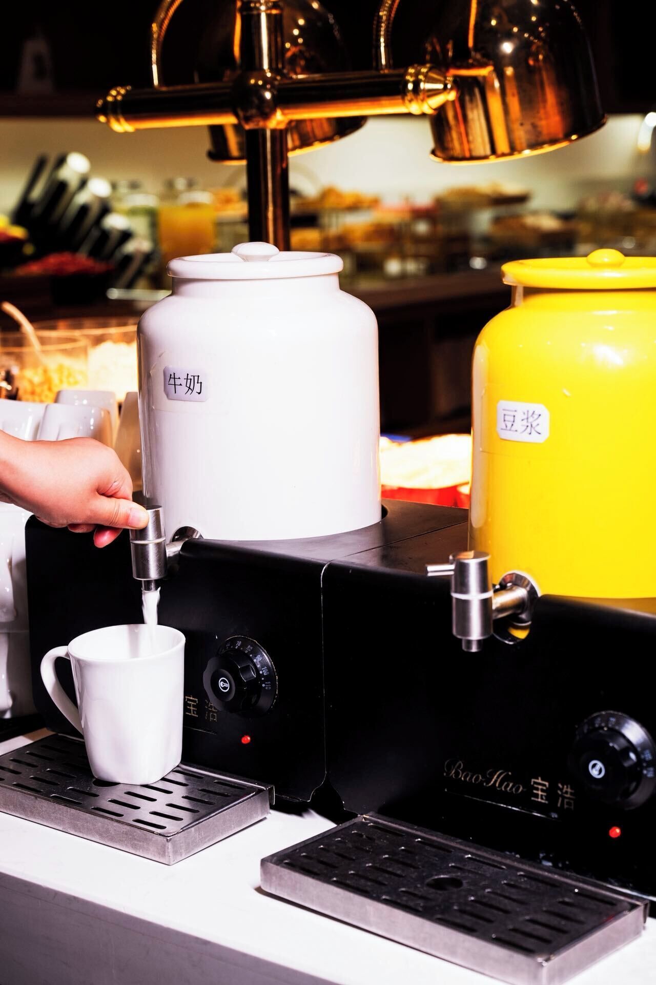 A coffee machine with a milk frother and a yellow container labeled '豆浆' (soy milk).