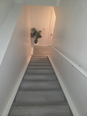 Eine Treppe mit Handlauf, einem Blumentopf und einer Tür am oberen Ende.