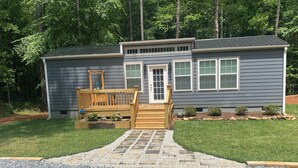 A house with a wooden deck, a stone pathway leading to the front door, and a 'WELCOME' sign. - Hudlow Hideaway…A perfect and secluded couple’s getaway with hot tub! (Union Mills)