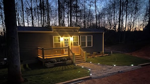 A small, single-story cabin with a front porch, a wooden deck, and a well-maintained lawn. - Hudlow Hideaway…A perfect and secluded couple’s getaway with hot tub! (Union Mills)