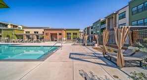 A pool area with lounge chairs and a building with multiple balconies. - Landing | Beautiful 2BD, Clubhouse, Courtyard (Santa Rosa)