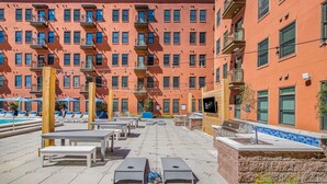 En takterrass med utomhusmöbler, en pool och ett barområde.