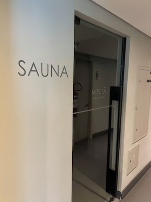 Eine Wand mit der Aufschrift 'SAUNA', die einen Saunabereich kennzeichnet.