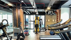 Een sportschool met loopbanden, krachtapparaten en diverse gewichten.