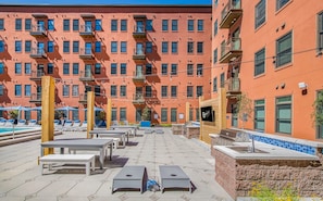 Eine Dachterrasse mit Sitzgelegenheiten im Freien, einem Pool und einer Bar.