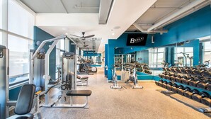 A gym with various exercise equipment, a bench, and dumbbells. - Landing | Spectacular 2BD in Downtown (Savannah)