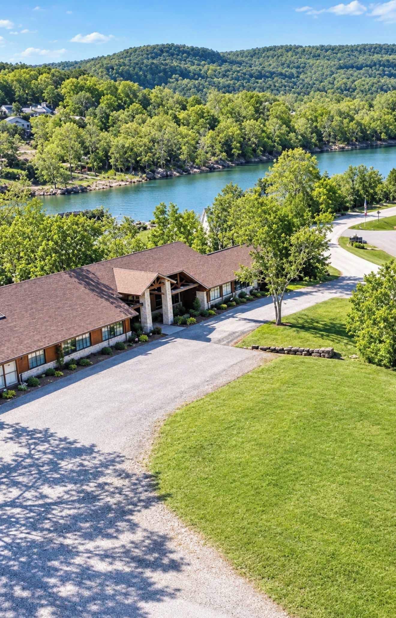 A building with a gravel driveway and a lawn in front.