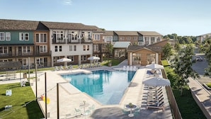 A residential building with a swimming pool, outdoor seating, and a green lawn. - Landing | Incredible 1BD, Clubhouse (Austin)