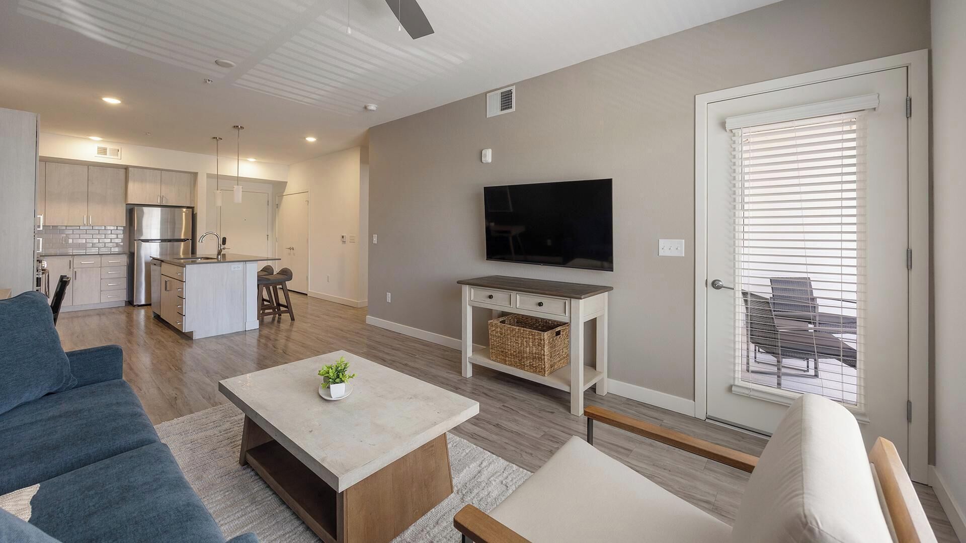 A modern apartment with a kitchen, dining area, living room, and balcony.