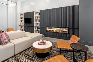 Ein modernes Wohnzimmer mit einer Couch, einem Couchtisch und einem Kamin.