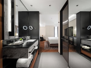 Un baño moderno con un espejo grande, lavamanos dobles y tocador.