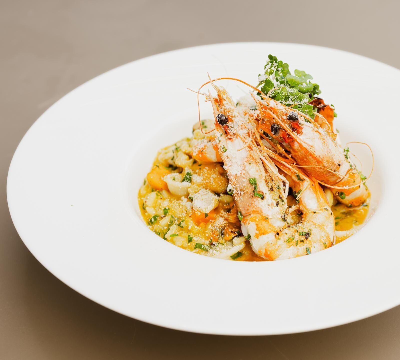 A plate with a seafood dish, possibly shrimp, on a white plate.