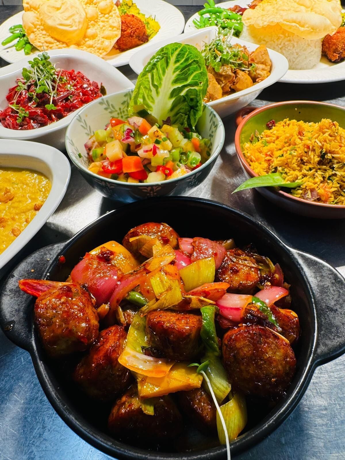 Una variedad de platos, incluyendo un tazón de carne con verduras, una porción de arroz y otros alimentos.