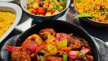 Una variedad de platos, incluyendo un tazón de carne con verduras, una porción de arroz y otros alimentos.