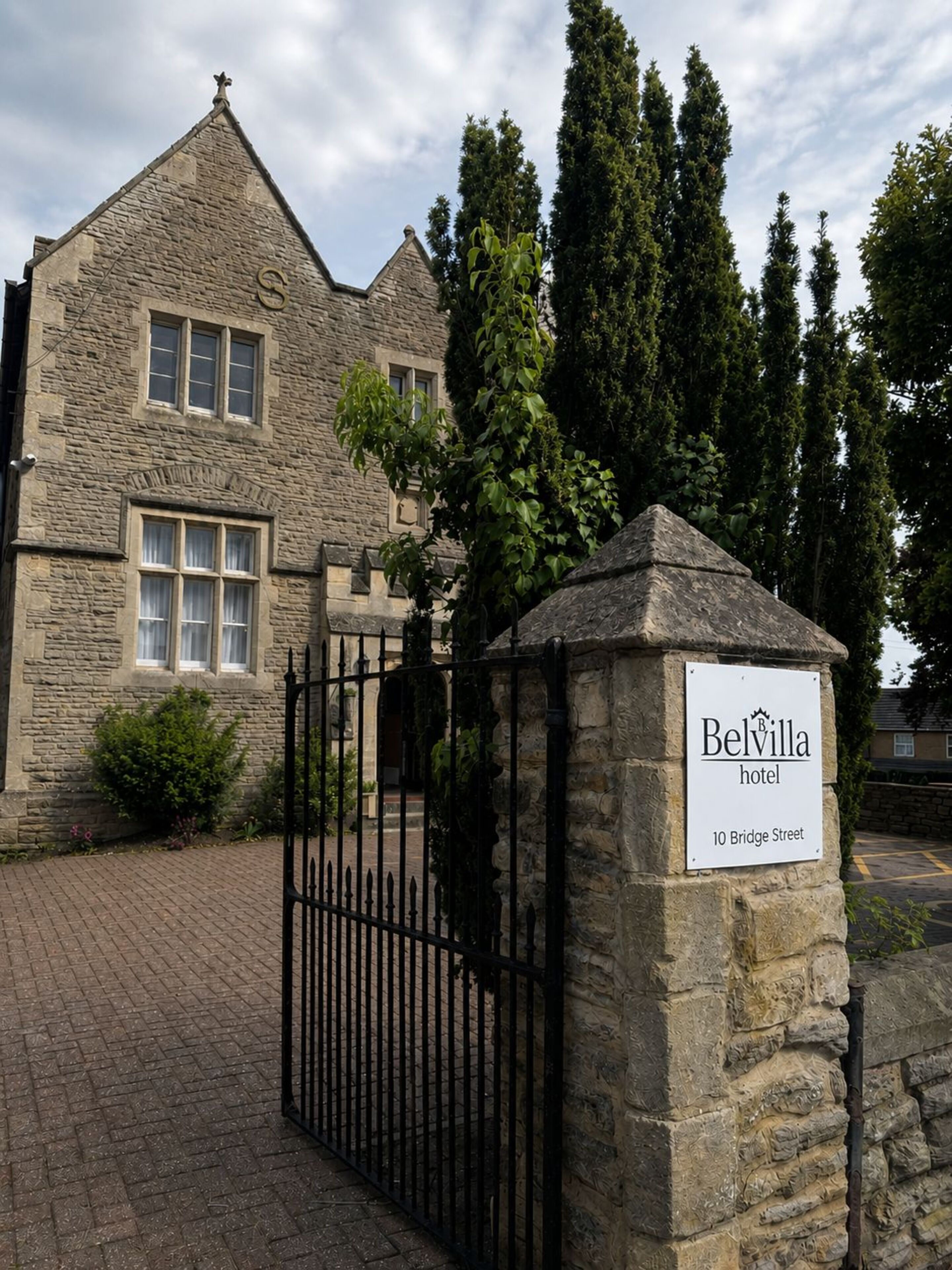 A stone building with a sign for Belvilla Hotel at 10 Bridge Street.