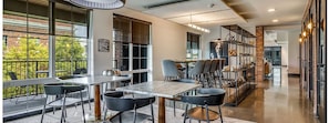 A modern dining area with a large window, a dining table, and chairs. - Landing | Stunning 1BD, Pool, Rooftop Lounge (Dallas)