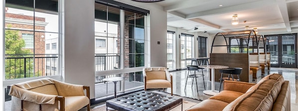 Ein modernes Interieur mit großen Fenstern, einer Couch, Stühlen und einem Tisch.