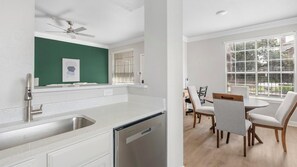 Eine moderne Küche mit Geschirrspüler, Deckenventilator und Essbereich mit Tisch und Stühlen.
