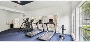 Ein Fitnessraum mit Laufbändern, Fahrrädern und Rudergeräten.