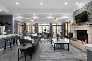 A modern living room with a sofa, coffee table, and dining area. - Landing | Stylish 1BD, Gym (McKinney)