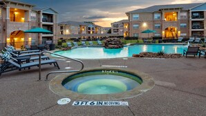 A swimming pool with lounge chairs, a hot tub, and a warning sign indicating no diving. - Landing | Incredible 1BD, Gym (McKinney)