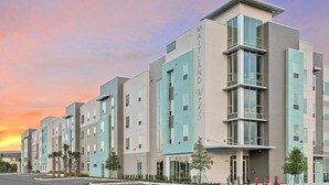 A modern multi-story hotel with a flat facade, large windows, and a prominent entrance. - Landing | Spectacular 1BD, Clubhouse, Gym (Lockhart)