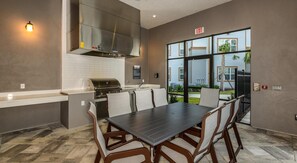 A modern kitchen with a built-in stove, a sink, and a large window overlooking a landscaped area. - Landing | Chic 1BD, Gym, Clubhouse (Apopka)