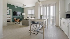 Un apartament modern amb cuina, zona de menjador i saló.