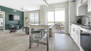 Een moderne keuken met een bar, een eethoek en een balkon met uitzicht.