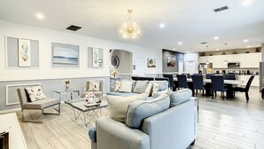 A modern living room with a sofa, coffee table, and dining area with chairs.
