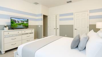 Un dormitorio con cama, televisor sobre un tocador y puerta que da a otra habitación.