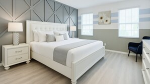 A bedroom with a bed, nightstands, a dresser, and a chair.