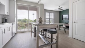 Een moderne keuken met een bar, grote ramen en uitzicht op de omgeving.