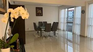 A modern dining area with a glass table and chairs, a potted plant, and a painting on the wall. - Apartment in central area for world cup (Naucalpan de Juárez)