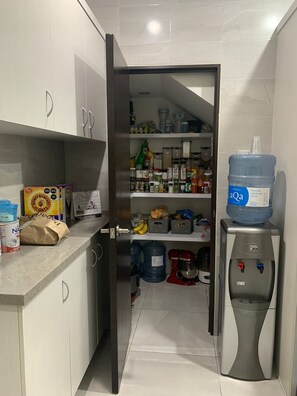 A kitchen with a pantry, a water dispenser, and various food items. - Apartment in central area for world cup (Naucalpan de Juárez)