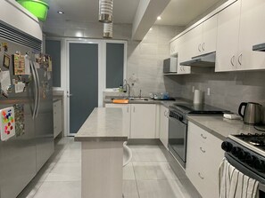 A modern kitchen with a refrigerator, stove, microwave, and sink. - Apartment in central area for world cup (Naucalpan de Juárez)