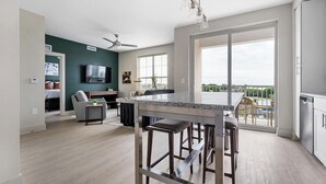 Une cuisine moderne avec un coin bar, de grandes fenêtres et une vue sur l’extérieur.