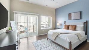 Ein Schlafzimmer mit Bett, Schreibtisch, Deckenventilator und Blick ins Freie.