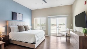 A modern bedroom with a bed, a desk, and a TV. - Landing | Stylish Studio, Pool, Rooftop Lounge (Springfield)