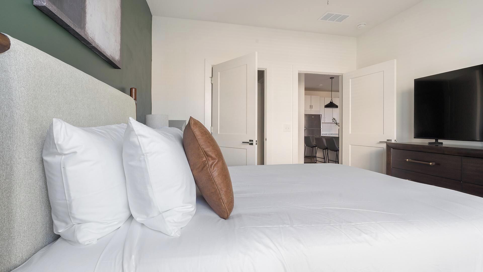 A hotel room with a bed, a television, a desk, and a chair.