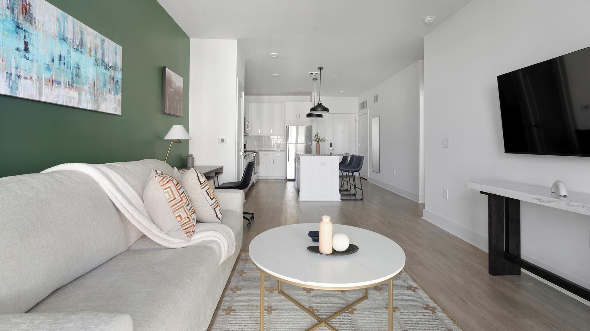 A modern living room with a sofa, a round coffee table, and a TV.