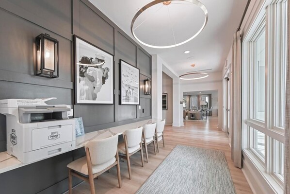 A modern interior with a long hallway, wall-mounted printer, framed pictures, and a large window. - Landing | Stylish 1BD, Clubhouse, Gym (Laurel)